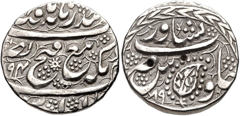 Both faces of a silver rupee covered in Persian script in relief, with small flower marks and a leaf in a wreath on one face.
