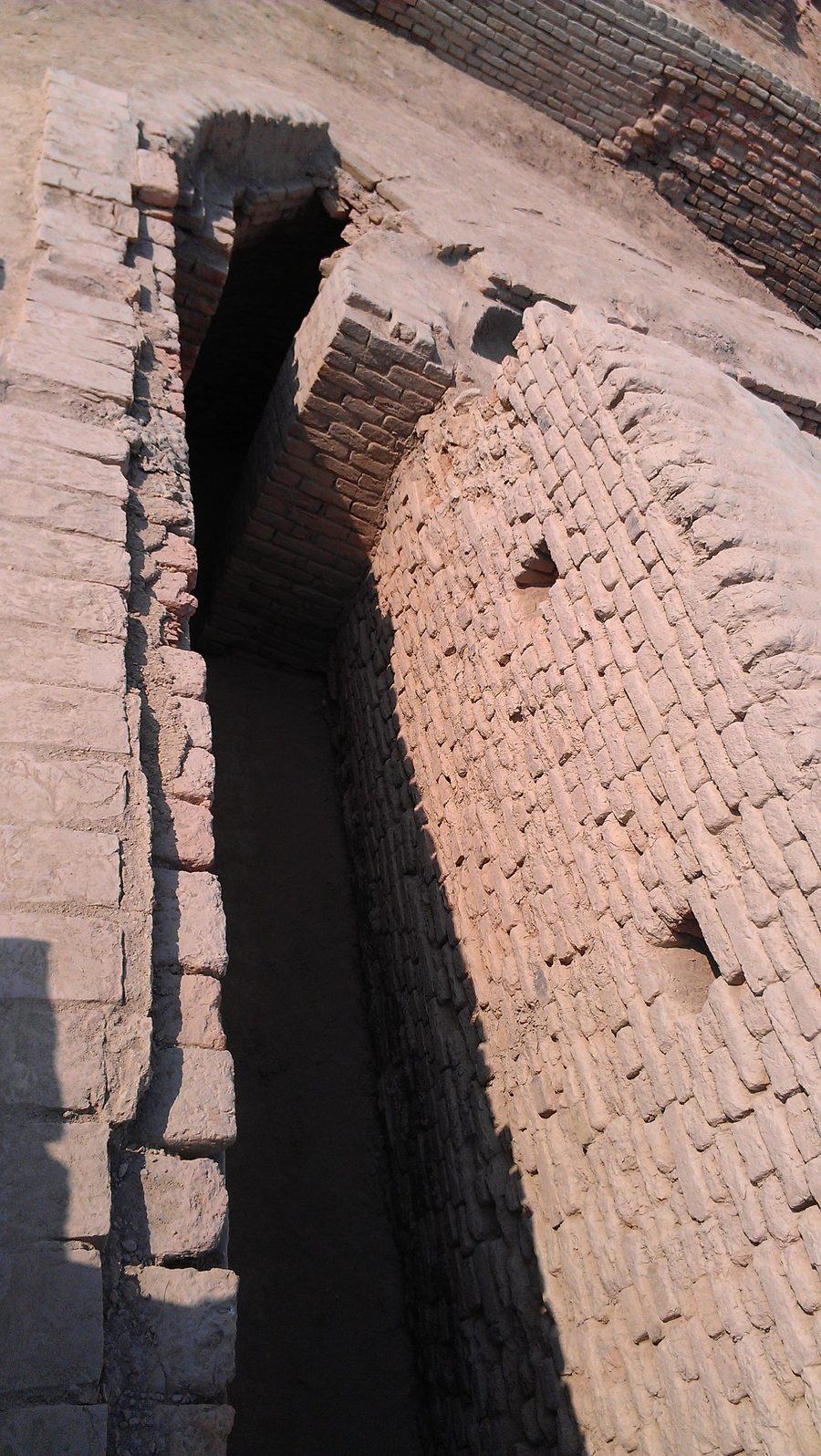 A tall, narrow brick drain at Mohenjo-daro, its roof made of brick courses that step inwards until they meet