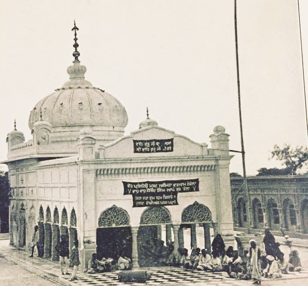 An old black-and-white photograph of a white domed shrine with an arcaded front and a small crowd gathered before it